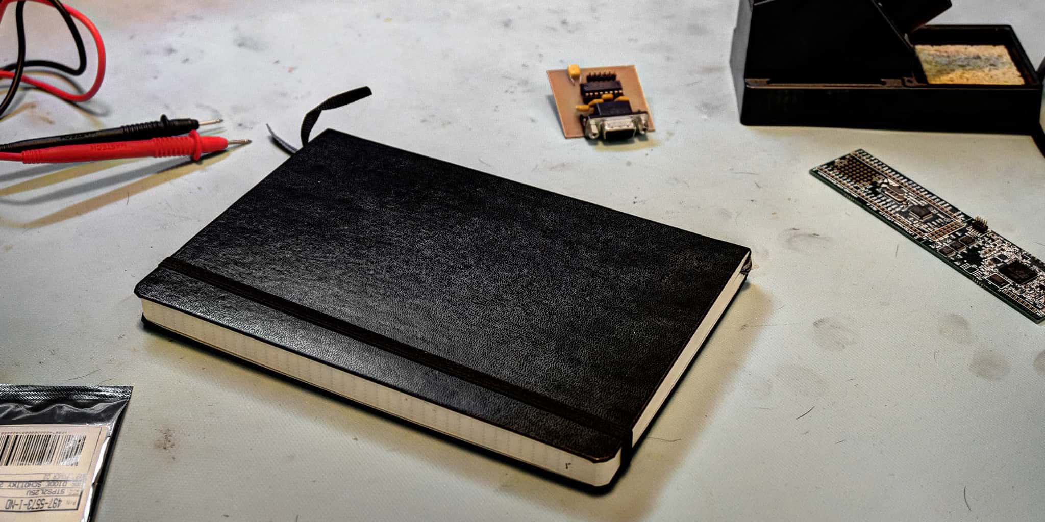 Electronic workbench with soldering iron, arm micro-controller, multimeter, and notebook