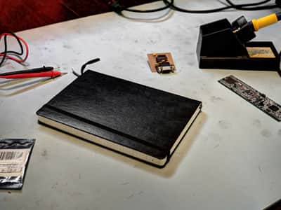 Electronic workbench with soldering iron, arm micro-controller, multimeter, and notebook